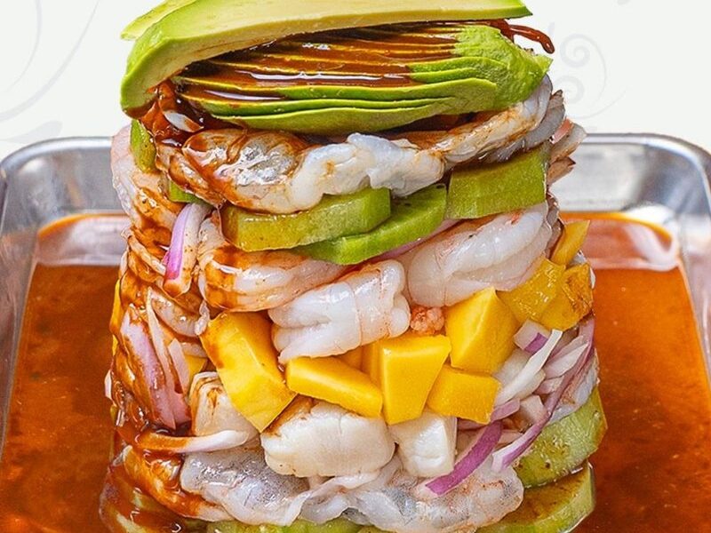 Seafood tower with shrimp, avocado, mango and cucumber over spicy citrus broth